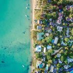 an aerial view of a beach and some houses near it